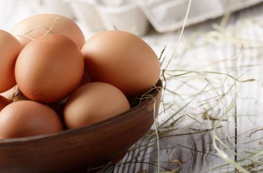 Ham organik kahverengi tavuk yumurtası kil kase beyaz mutfak ahşap tablo