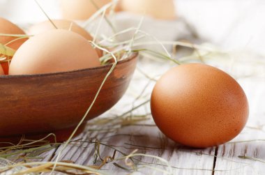 Ham organik kahverengi tavuk yumurtası kil kase beyaz mutfak ahşap tablo