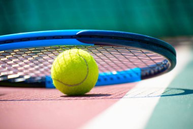 Tennis racquet and ball lying on the court. Healthy lifestyle concept
