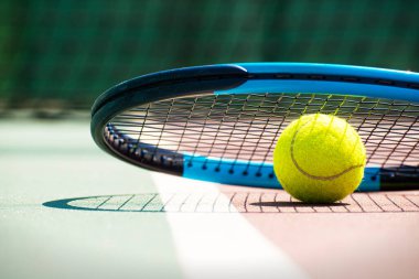 Tennis racquet and ball lying on the court. Healthy lifestyle concept