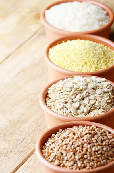 stock image Cereal grains set in ceramic bowls on wooden table