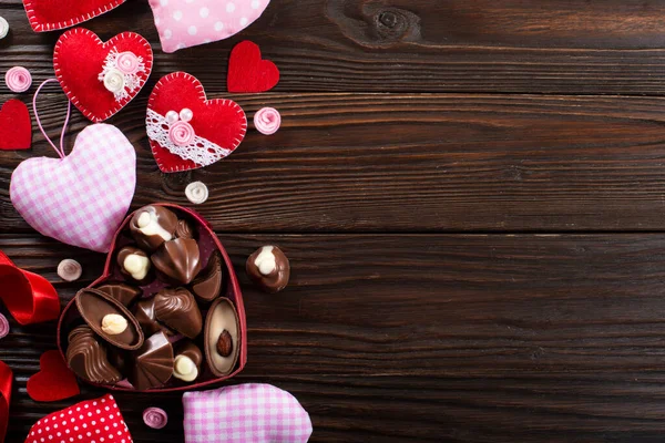 情人节巧克力盒和手工制作的心放在木制桌子上 免版税图库照片
