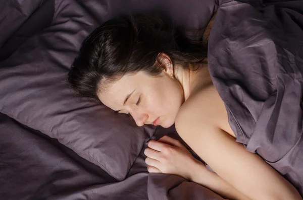 躺在床上的年轻高加索女人放松的脸的画像 休息概念 免版税图库照片