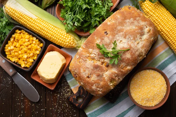厨房木制桌子上有新鲜玉米面包的切菜板 — 图库照片