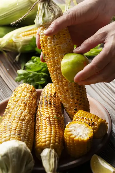 Female Hands Rubbing Roasted Sweet Corn Cob Lime Stock Picture