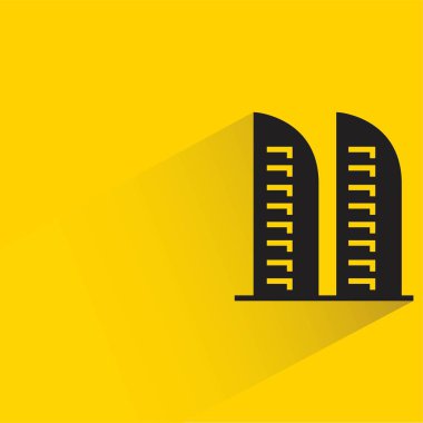 Sarı arka planda gölgesi olan ofis kulesi
