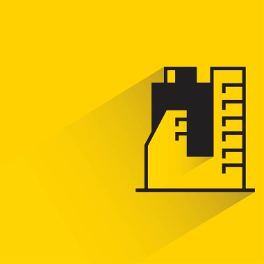 sarı arka planda gölgesi olan ofis binası