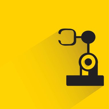 Sarı arka planda gölgesi olan endüstriyel robot kol