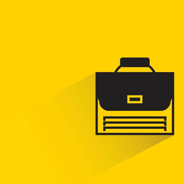 黄色の背景に影のあるブリーフケース — ストックベクタ