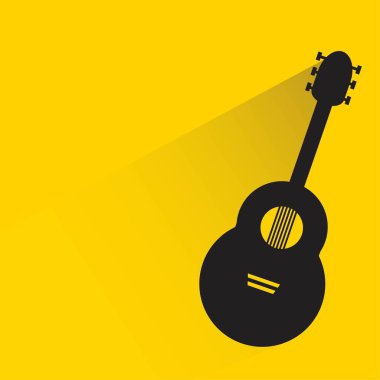 Sarı arka planda gölgesi olan gitar.