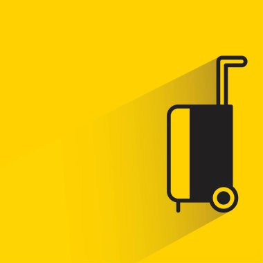 sarı arka planda gölgesi olan valizler