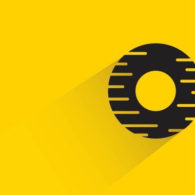 Sarı arka planda gölgesi olan donut tatlısı.