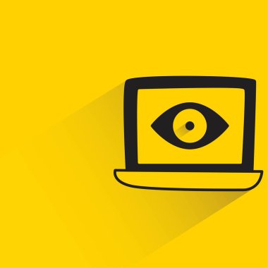 Sarı arka planda gölgesi olan dizüstü bilgisayarda göz görüntüsü