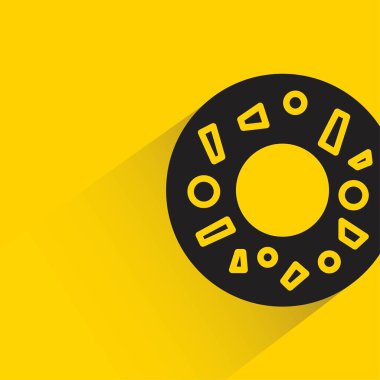 Sarı arka planda gölgesi olan donut tatlısı.