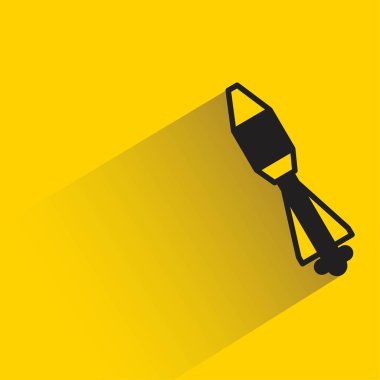 Sarı arkaplanda gölgesi olan füze simgesi