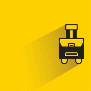 sarı arka planda gölgesi olan valiz ve çanta.