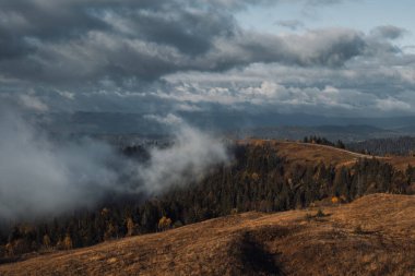 Dağ sırası. Sonbahar bulutlu bir gün manzarası ve uzun bir yol.. 