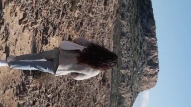 Arkadan genç bir kadın, Kıbrıs Rum Kesimi 'nin Ayia Napa kentindeki Cape Greco dağına doğru çölde yürüyor.. 
