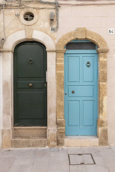 Two doors facade of old town in Polignano a Mare. Colorful doors in stone mediaval wall