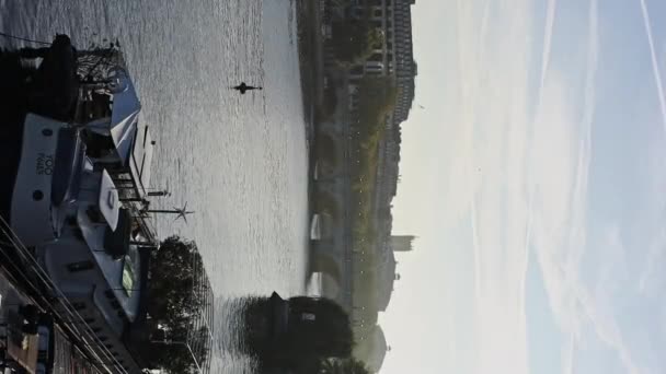 パリの背景にある船とアーチブリッジを持つセーヌ川付近の朝の垂直ビデオ 朝の空っぽの晴れた時間 — ストック動画