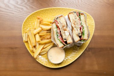 Akşam yemeğinde peynirli, etli ve kızarmış patatesli sandviç.