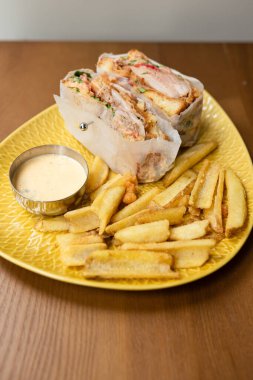 Akşam yemeğinde peynirli, etli ve kızarmış patatesli sandviç.