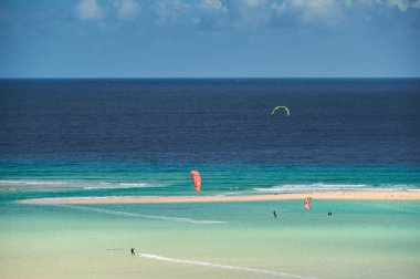 Mavi gökyüzü olan bir sahilde sörfçünün güzel bir fotoğrafı.