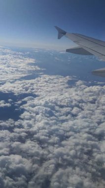 Bir uçak kanadının, bulutların, dağların ve yerin penceresinden bak..