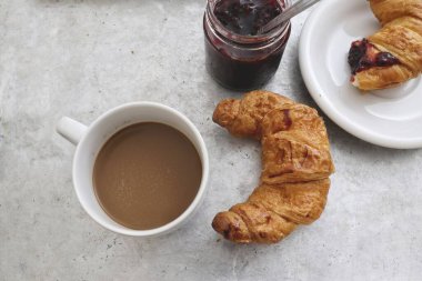 Çilekli kruvasan ekmeği ve kahve fincanı