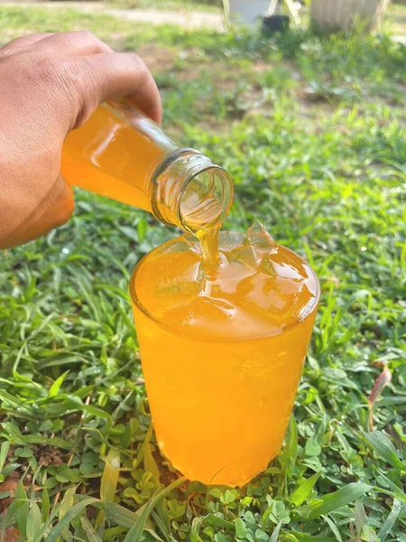 Tuang Minuman Ringan Oranye Dengan Batu — Stok Foto