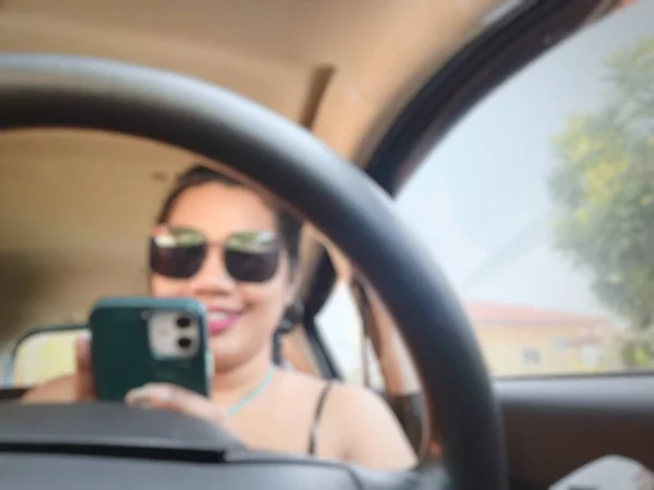 Borroso Mujer Asiática Sonrisa Feliz Conducir Coche Con Teléfono Inteligente — Foto de Stock