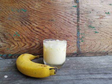 Ahşap zemin üzerinde muzlu süt smoothie