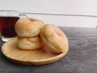 Tahta arka planda şekerli donut kahvaltısı.