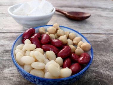 Ahşap zemin üzerinde kırmızı fasulye ve nohut peyniri.