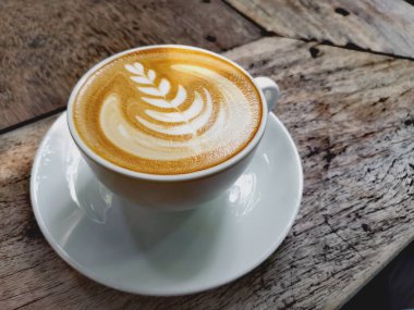 Kahverengi ahşap masada Latte sanatı