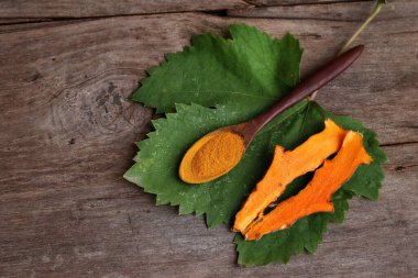 Ahşap arka planda zerdeçal kökü tozu