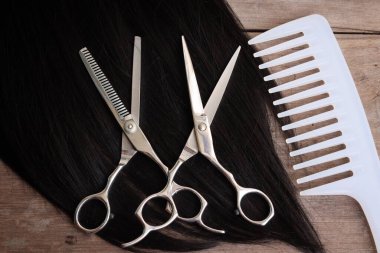 Ahşap arka plan üzerinde saç kesme makası