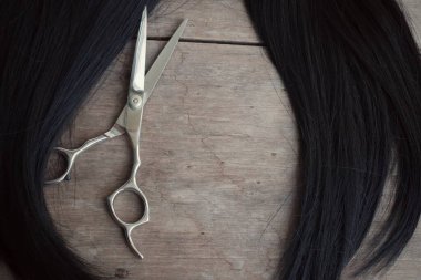 Ahşap arka plan üzerinde saç kesme makası