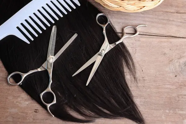 Ahşap arka plan üzerinde saç kesme makası