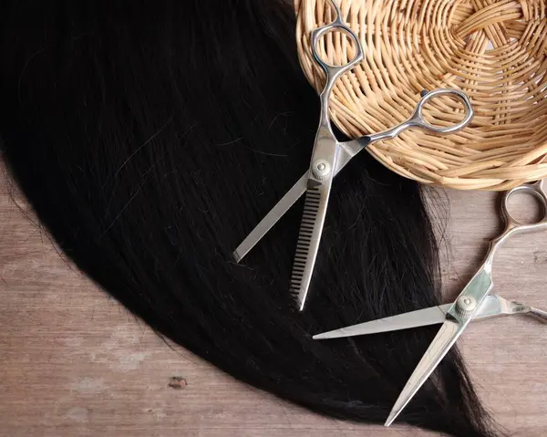 Ahşap arka plan üzerinde saç kesme makası