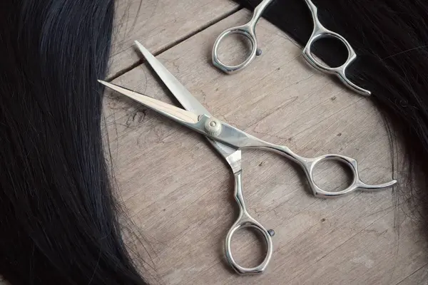 Ahşap arka plan üzerinde saç kesme makası