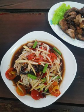 Papaya salatası ahşap arka plan üzerinde Tayland Gıda