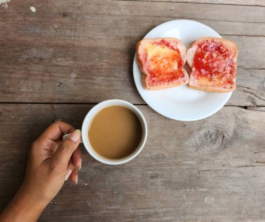 Çilekli tost ekmeği ve tereyağlı kahve fincanı.