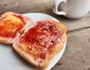 Çilekli tost ekmeği ve tereyağlı kahve fincanı.