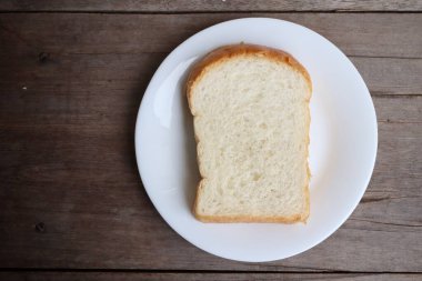 Tahta arka planda dilimlenmiş ekmek kahvaltısı.