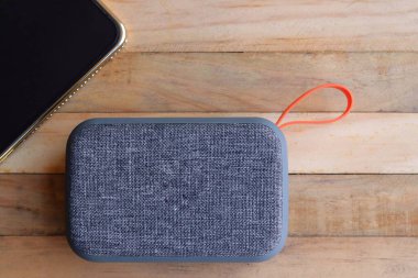 Gri bluetooth hoparlör ve akıllı telefon