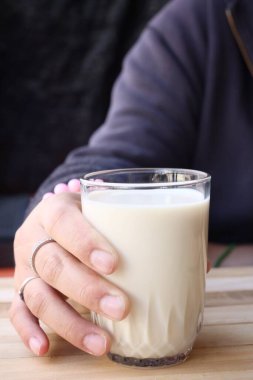 Fofu sütlü içecek ve el.