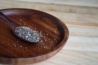 Kahverengi ahşap arka planda Chia tohumları