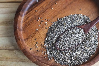 Kahverengi ahşap arka planda Chia tohumları