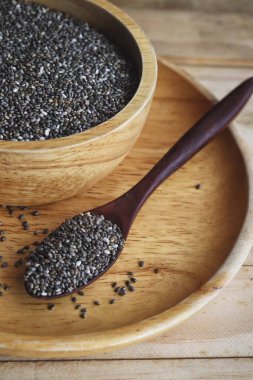 Kahverengi ahşap arka planda Chia tohumları